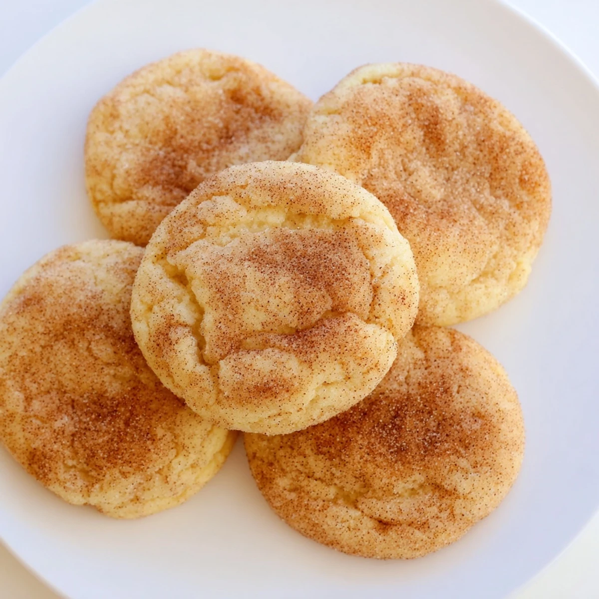Close-up of freshly baked Snickerdoodles, showing a wonderfully crinkled surface and sugary coating.