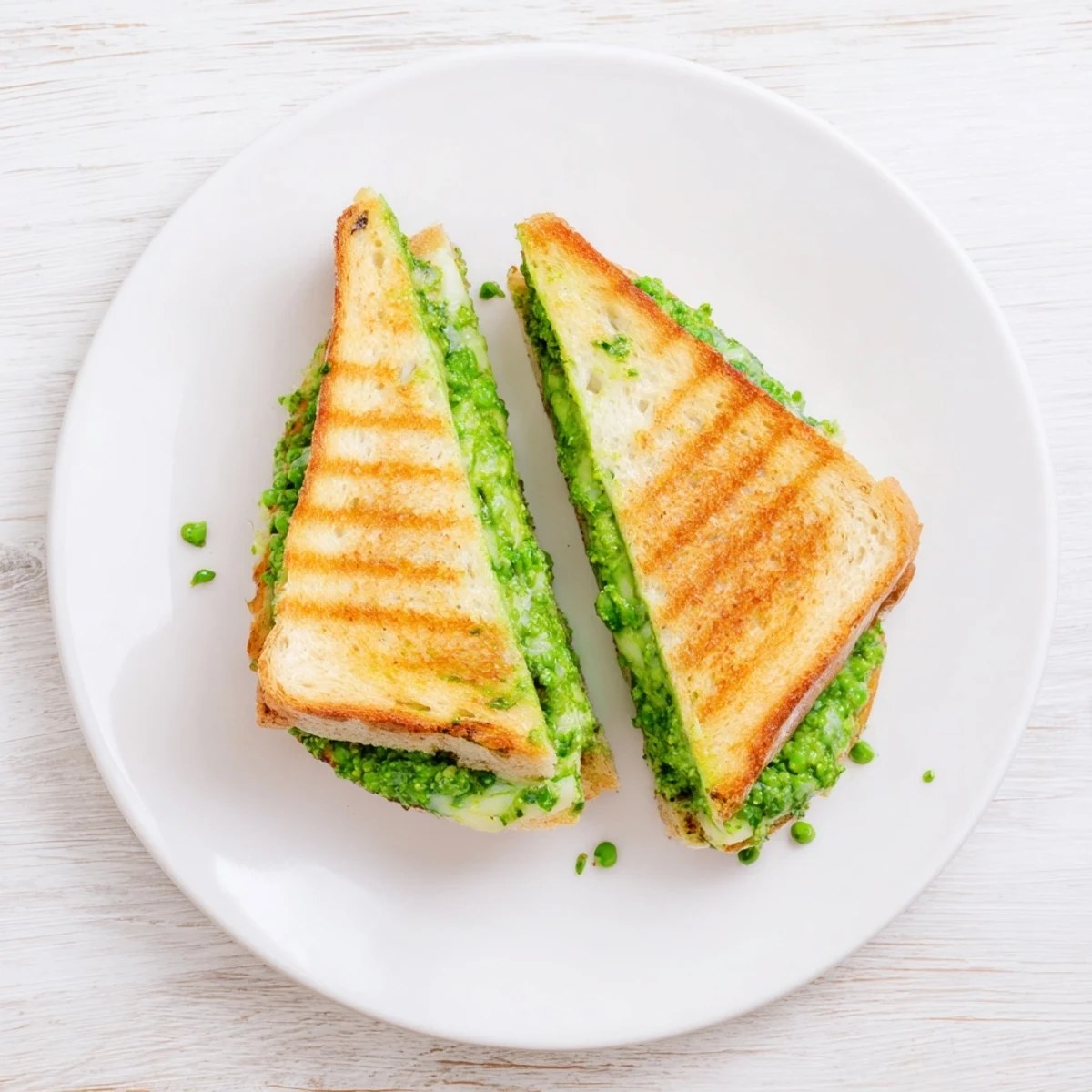 A vibrant Spring Pea Pesto Grilled Cheese with golden sourdough and melted mozzarella, served warm.