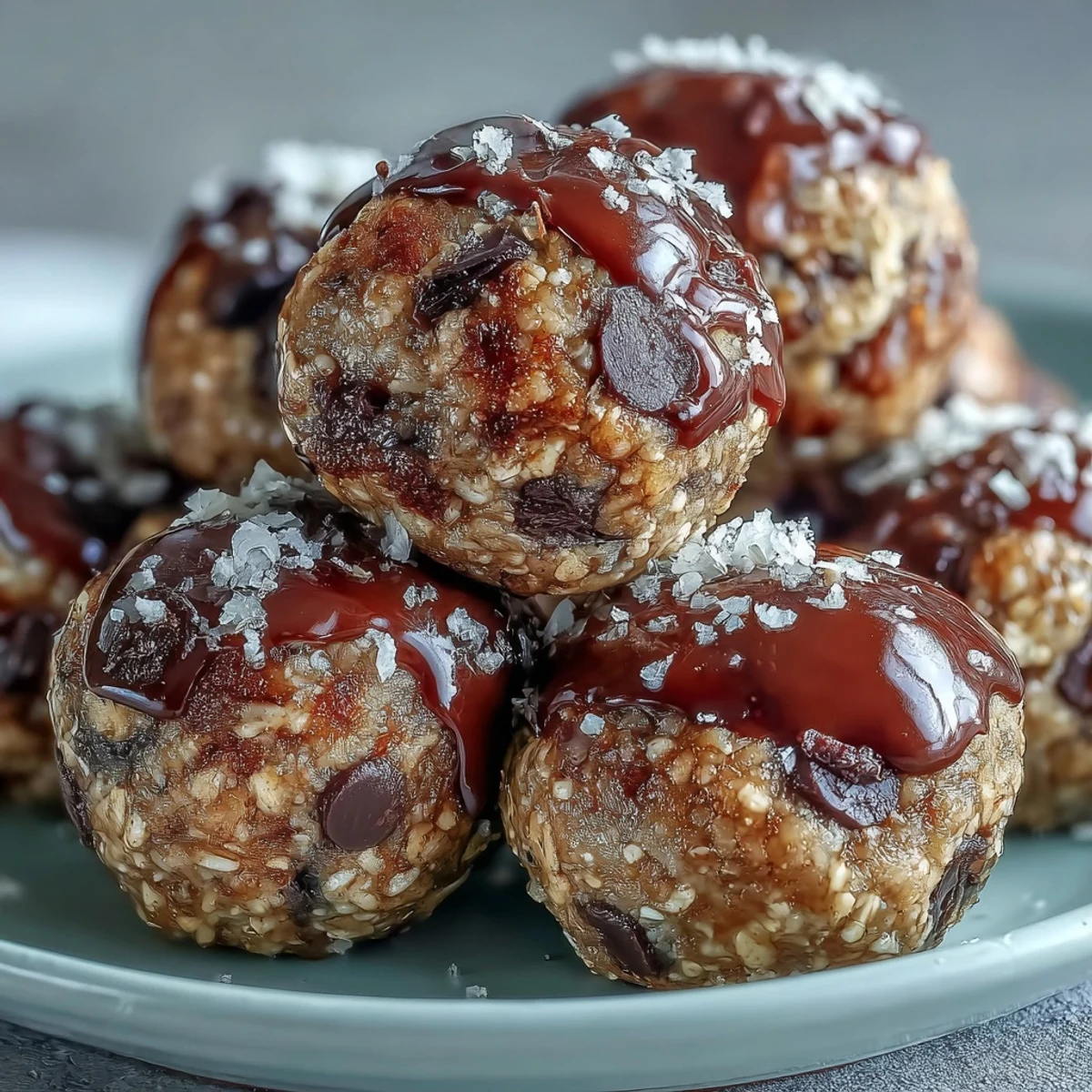 Homemade Banana Chocolate Chip Energy Balls arranged in a clear glass jar, with a small bowl of chocolate chips and oat flakes nearby, suggesting a fresh, wholesome snack ready to grab and go.