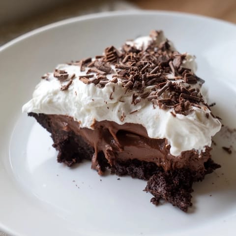 A luscious slice of Mississippi Mud Pie, showcasing layers of creamy chocolate and whipped cream.