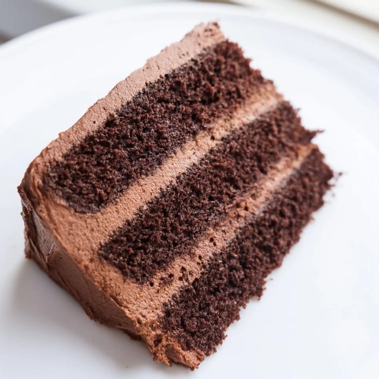 This layered Devil's Food Cake reveals moist chocolate cake and fluffy frosting, appealing to the eye.