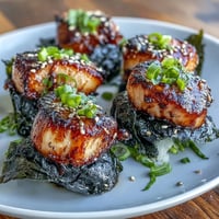 Pan-seared scallops wrapped in crisp nori seaweed, served with